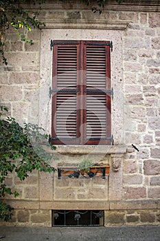 Vintage window with shutters on the wall of an old house..window in Cunda Turkey old construction and wood the historical