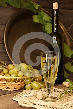 Vintage wine glass against background cluster of grapes and wine