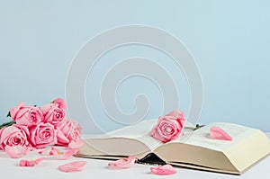 Vintage withered pink pastel rose flowers with open book