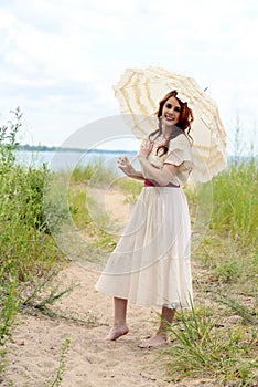 Vintage woman with parasol on beach path