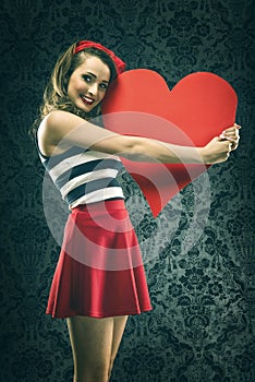 Vintage woman in red dress embraced big paper heart photo