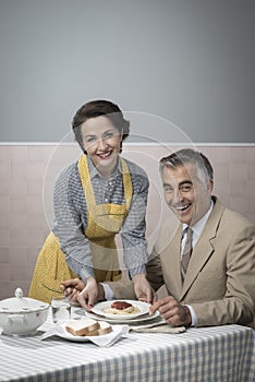 Vintage woman serving lunch to her husband