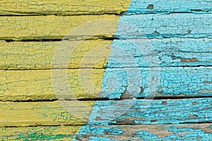 Vintage wood background with peeling yellow and blue paint.