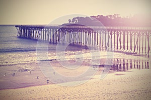 Vintage wood bridge at beach sunset, California, USA.