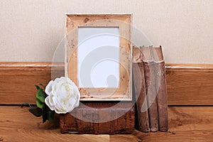 Vintage wood frame with old books on table.