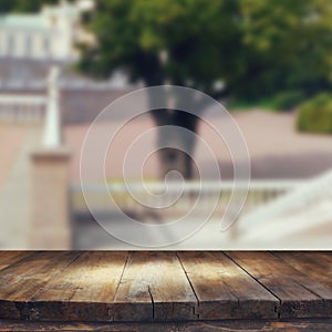 Vintage wooden board table in front of rustic counrty garden landscape photo