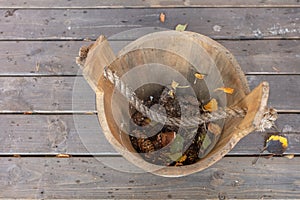 Vintage, wooden bucket with leaves, top view. Autumn background