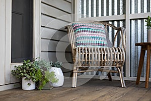 Vintage wooden chair with a clorful pillow in the yard with plants