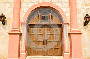 Vintage wooden door with carriage lamps and columns at the Santa Barbara mission