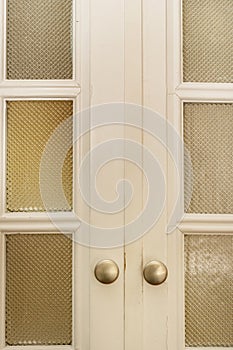 Vintage wooden door with translucent glass and small circular metal knobs