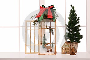 Vintage wooden lantern with beautiful Christmas decor on window sill indoors