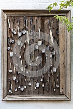 Vintage wooden panno with old cutlery on a white wall