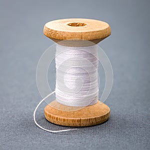 Vintage wooden spool of white sewing thread