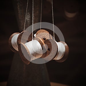 Vintage wooden spools of white threads closeup. Thread shabby bobbins with white cotton yarn.