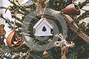 Vintage wooden toy house on Christmas tree. Natural Xmas ornaments for Christmas tree, zero-waste