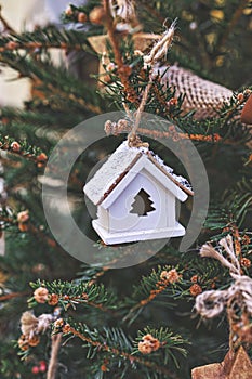 Vintage wooden toy house on Christmas tree. Natural Xmas ornaments for Christmas tree, zero-waste