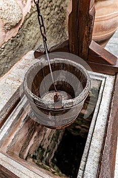 Vintage wooden well bucket and stone well for water usage in Meteora Monasteries, Greece