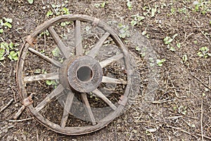 Vintage wooden wheel on earth. Copy space