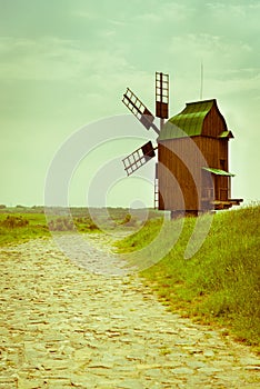 Vintage wooden windmill on stone road