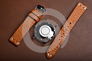 Vintage wristwatch on a brown leather background. Classic watch straps, Genuine handcraft italian calfskin leather.