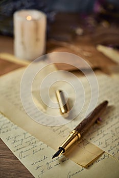 Vintage writing utensils on a wooden table, old watch, papers, letters, envelopes and scissors