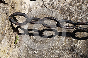 vintage wrought iron chain on old stone wall