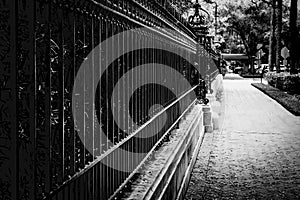 Vintage wrought iron fence and brick sidewalk