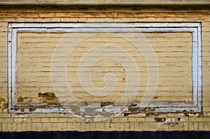 Vintage yellow brick wall with white painted rectangle. Background of brick wall texture. Mixed color industrial brick wall