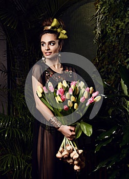 Vintage young woman with big bouquet of fresh spring white tulip flowers. Spring style green leaves