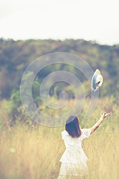 Young woman satnding and throwing hat
