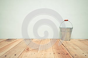 Vintage zinc bucket on wooden table and cement wall background