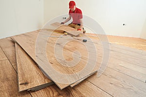 vinyl floor installation. Close-up hands of worker at home flooring renovation.