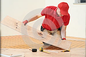 vinyl floor installation. Close-up hands of worker at home flooring renovation.