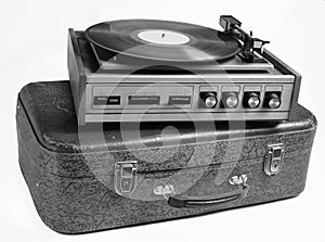 Vinyl player on an old leather suitcase isolated on a white background.