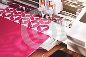 vinyl plotter cuts round stickers with peace dove symbol from pink adhesive foil in vivid shadowy light