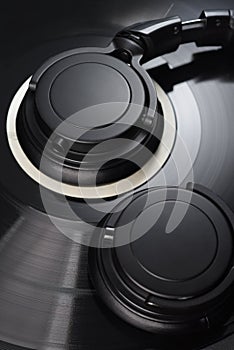 Vinyl record with black headphones close-up