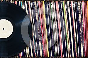Vinyl record with copy space in front of a collection of albums (dummy titles) photo