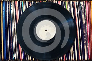 Vinyl record with copy space in front of a collection of albums, vintage process photo