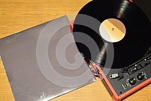 Vinyl record player with vinyl record and sleeve