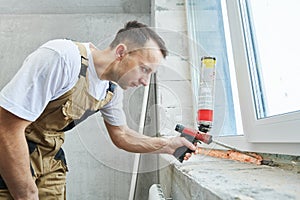 Vinyl windowsill installation. Filling polyurethane foam