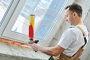 Vinyl windowsill installation. Filling polyurethane foam