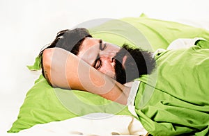 Violations of sleep and wakefulness. Young man sleeping on soft pillows in bed at home. Man bearded hipster having