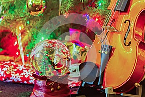 Violen with decorated christmas tree presents and snow ball