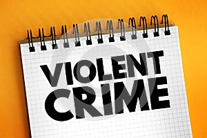 Violent crime - in which an offender or perpetrator uses or threatens to use harmful force upon a victim, text concept on notepad photo