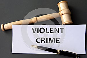 VIOLENT CRIME - words on white paper on dark background with judge\'s gavel