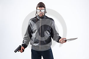 Violent young man holding a gun and a knife