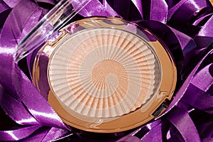 Violet background. Cosmetic macro. Macro photography of highlighter for makeup on a violet background. Make up concept