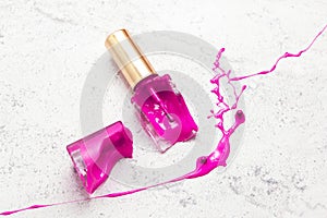 violet broken nail polish bottle on marble, purple dye color splash and suffusion