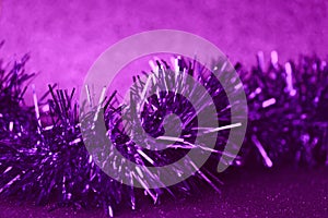 Violet christmas decorations on shiny purple background