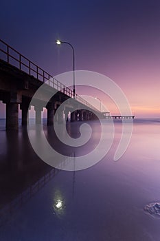 Violet color in the evening in the beach under the long pier photo